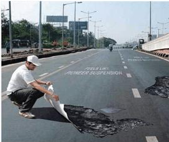 Mann flickt eine beschädigte Straße mit Asphalt.